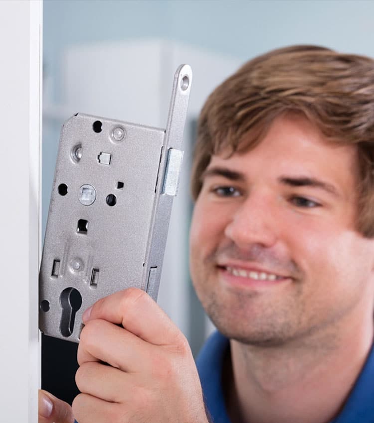 Close-up Of Man's Hand Installing Door Lock At Home — Expert Trade Services in Burleigh Heads, QLD