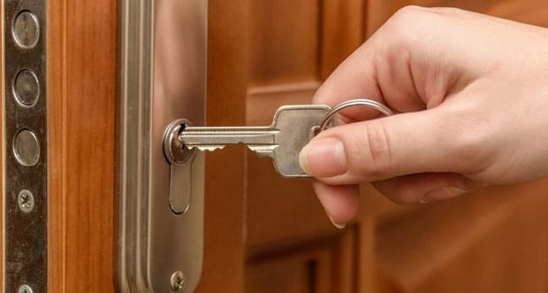 Close-up Photo Of Hands Opening Door WIth Key — Plumbers in Robina, QLD