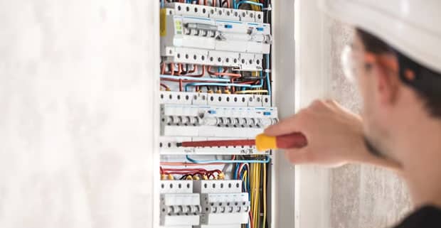 Electrical Technician Fixing Switchboard With Fuses — Locksmiths in Varsity Lakes, QLD