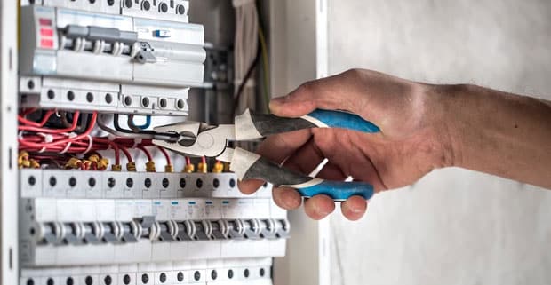 Electrical Technician Working In Switchboard With Fuses — Locksmiths in Burleigh Waters, QLD