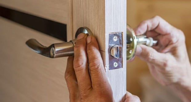 Man Installing New Door Locker — Electricians in Main Beach, QLD