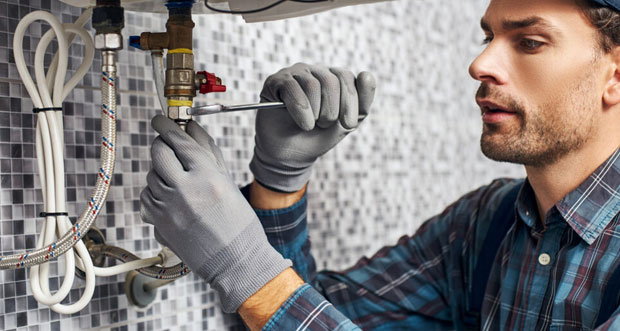 Man Installing Water Heater On The Bathroom — Plumbers in Mermaid Waters, QLD
