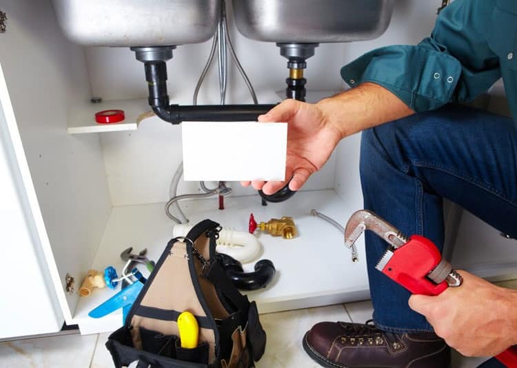 Plumber WIth Plumbing Tools In Kitchen — Expert Trade Services in Burleigh Heads, QLD