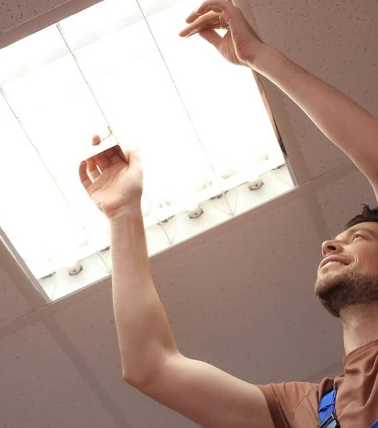 Man Changing Light Bulb Inside The Lamp — Expert Trade Services in Burleigh Heads, QLD