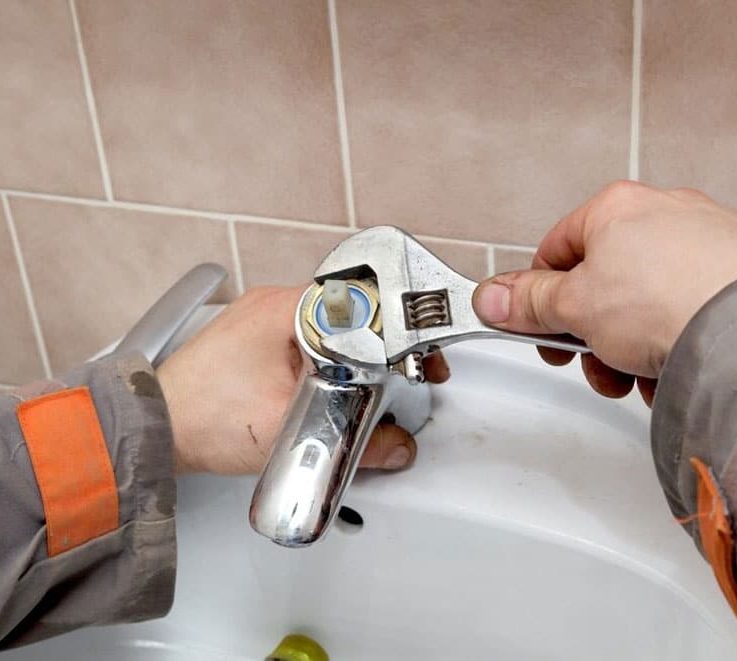 Plumber Fixing Water Tap In A Bathroom Spinner — Plumbers in Robina, QLD